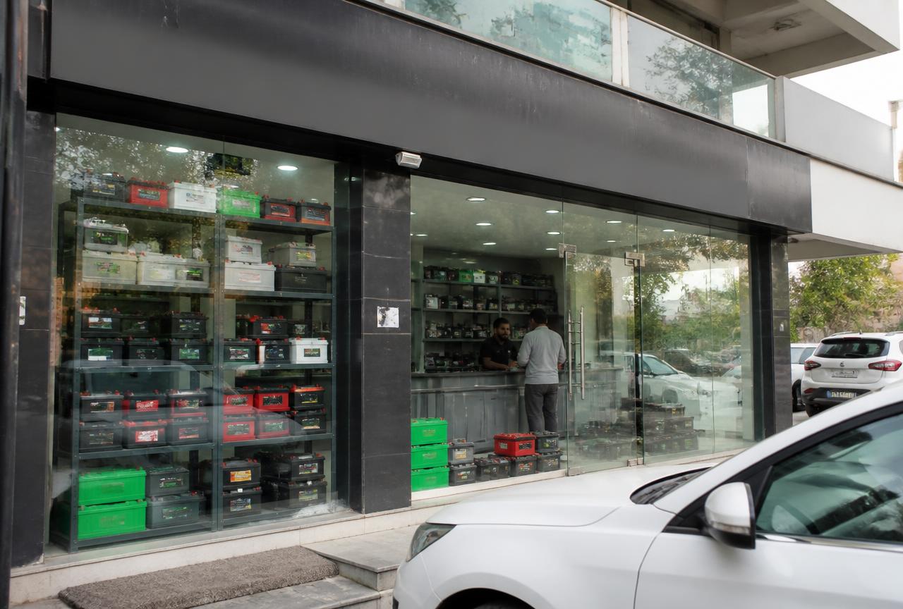 Car battery shop storefront with batteries stacked on shelves in Gurugram, Haryana